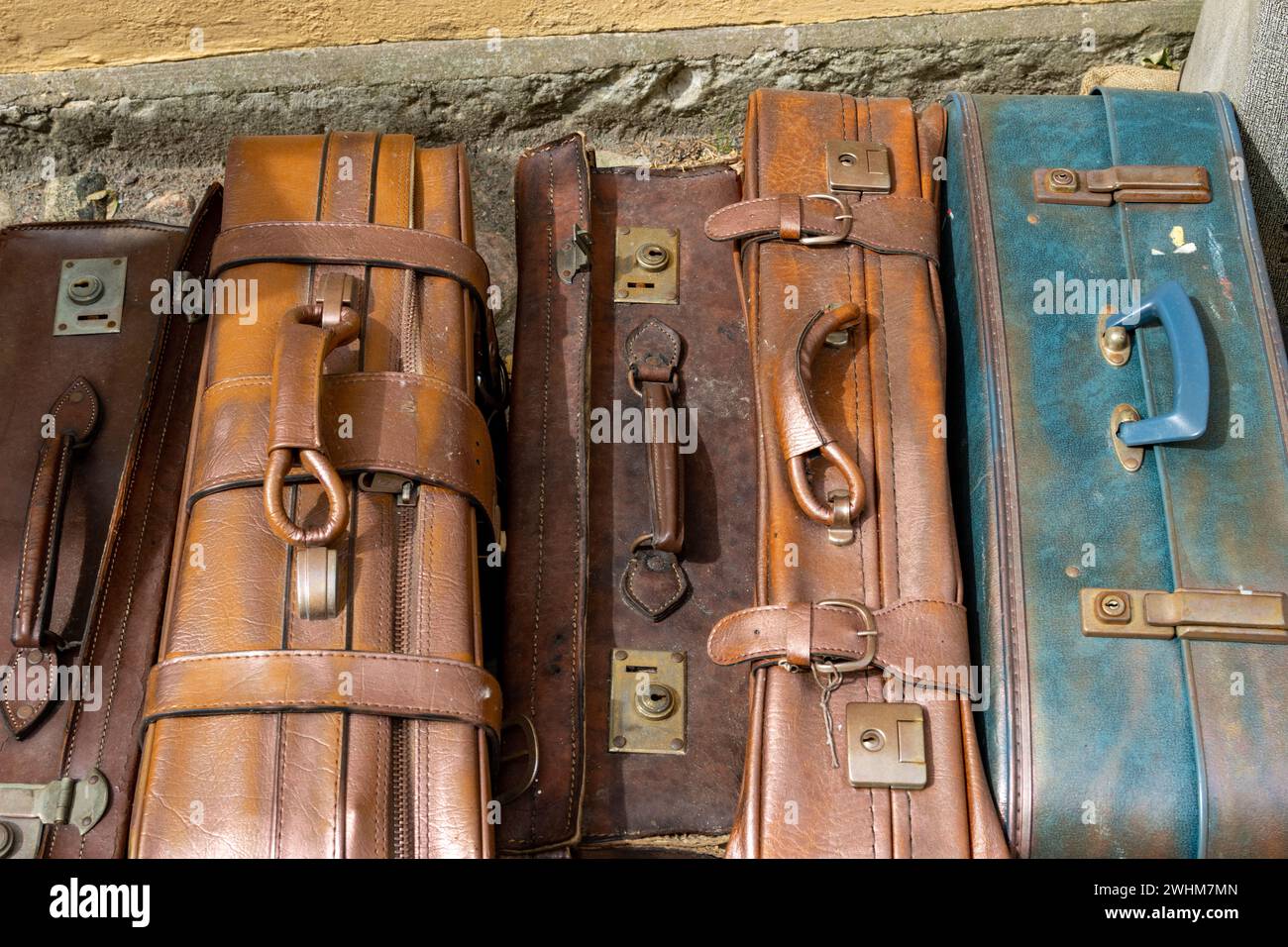 Alte Lederkoffer stehen an einer Wand. Taschen werden verwendet und verwittert Stockfoto