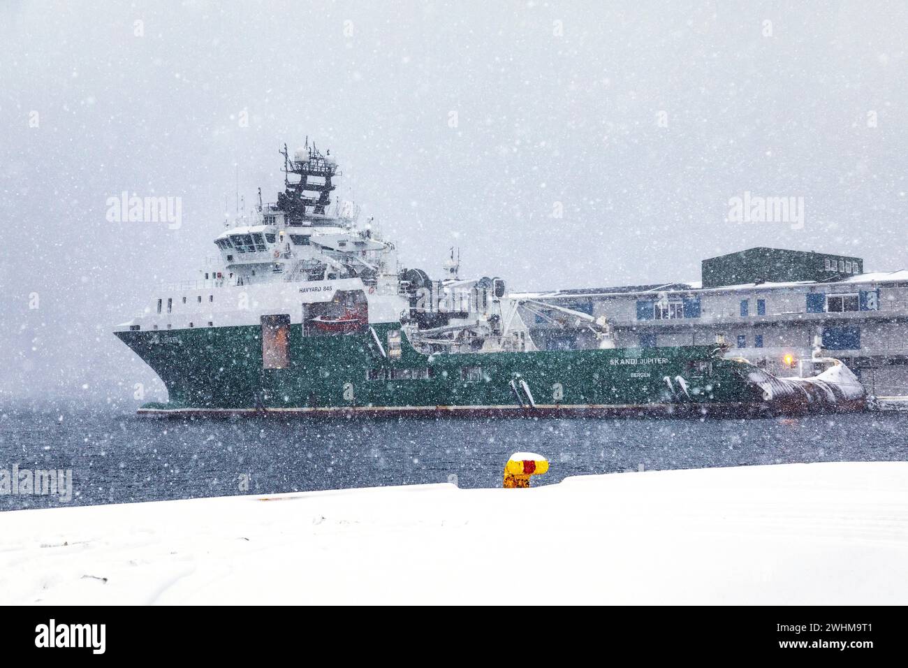 Offshore-Schlepper Skandi Jupiter (ehemals Havila Jupiter) bei schwerem Schnee am Kai Skoltegrunnskaien im Hafen von Bergen, Norwegen. Stockfoto
