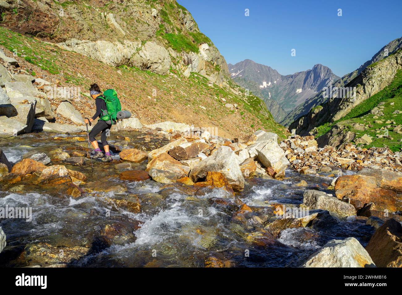 Garganta de escursionista vadeando un torrente de montaÃ±a Stockfoto