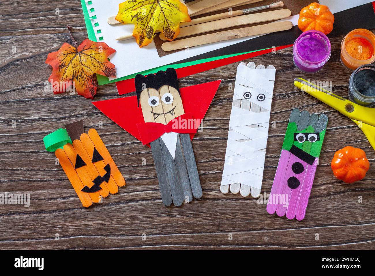 Halloween-Geister, Kürbis, Mumie und Vampir Spielzeug Geschenk Sticks Marionetten auf Holztisch. Handgefertigt. Projekt der Kreativität von Kindern, Stockfoto
