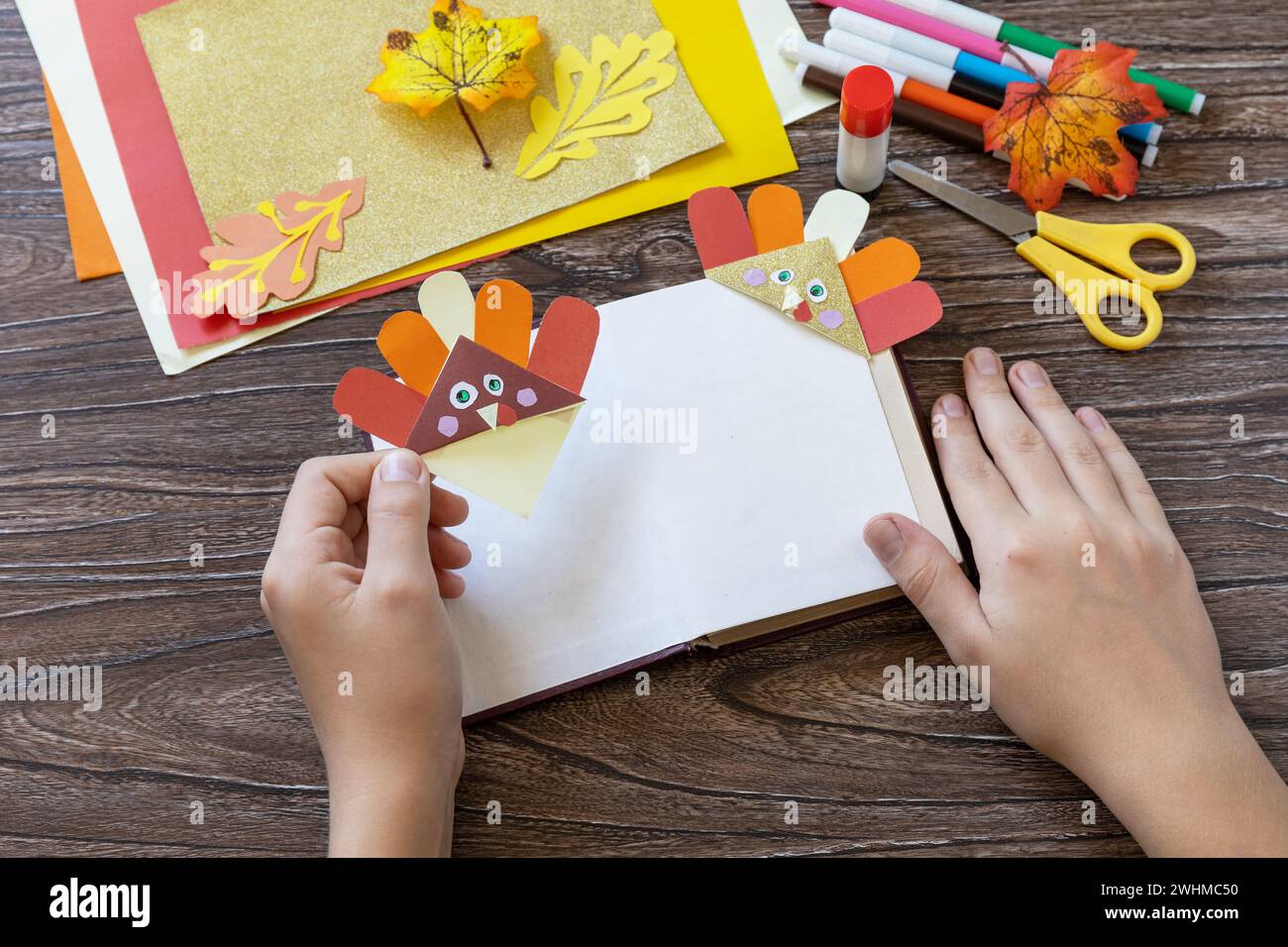In den Händen eines Kindes Thanksgiving Handwerk Lesezeichen putenpapier. Kinderkunstprojekt, handgefertigt, Basteln für Kinder. Stockfoto