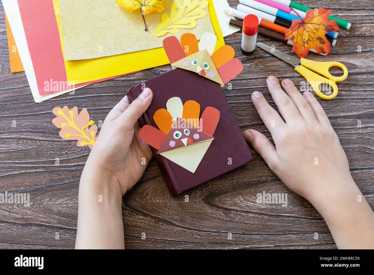 In den Händen eines Kindes Thanksgiving Handwerk Lesezeichen putenpapier. Kinderkunstprojekt, handgefertigt, Basteln für Kinder. Stockfoto