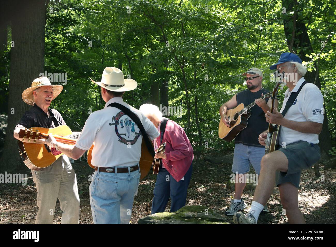 Musiker jammen in fließenden Gruppen unter Bäumen beim Old Fiddlers Picknick Stockfoto