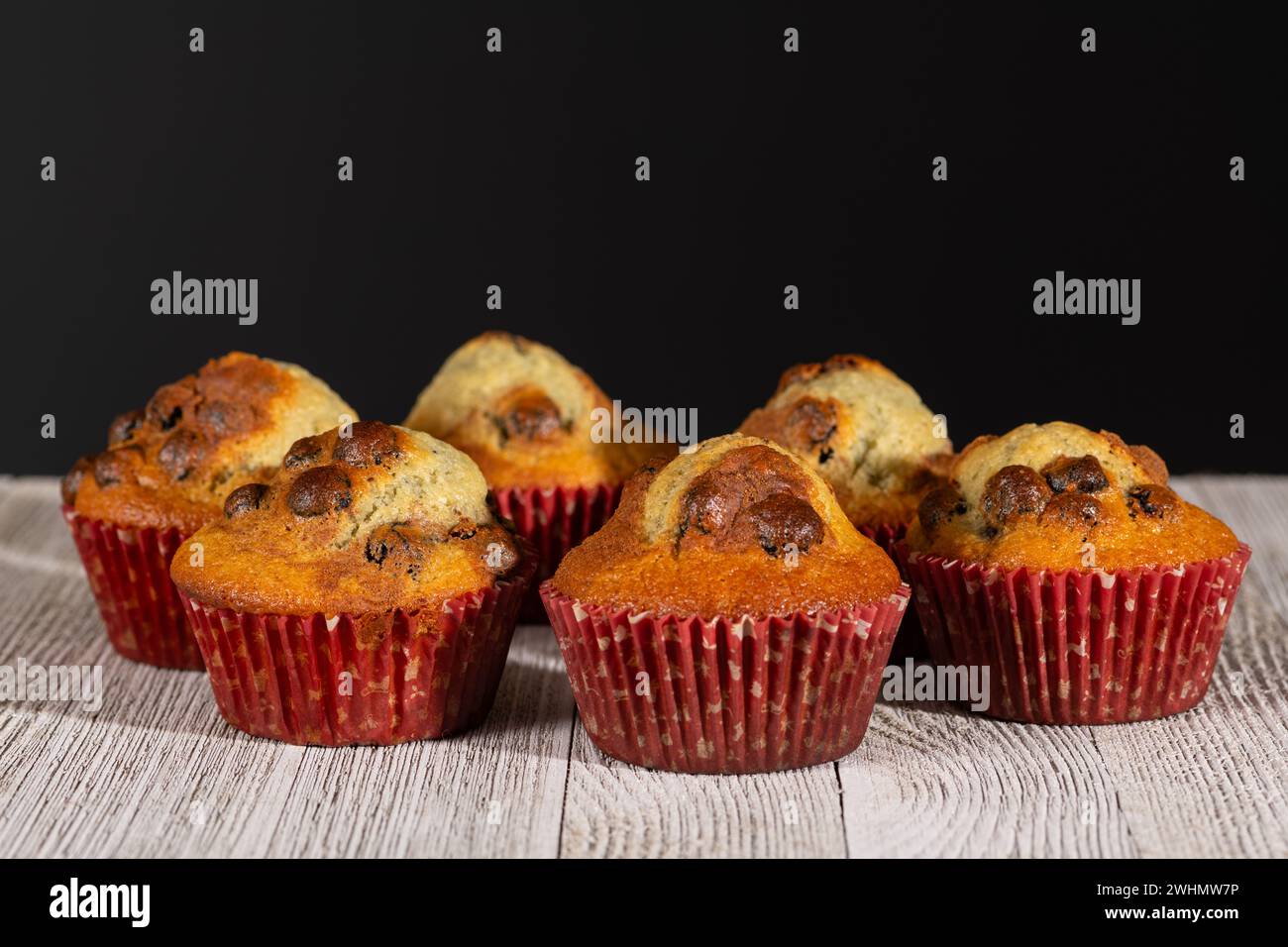 Nahaufnahme von gerade gebackenen Heidelbeermuffins auf rustikalem Tisch. Selektiver Fokus auf Mittelmuffins. Stockfoto