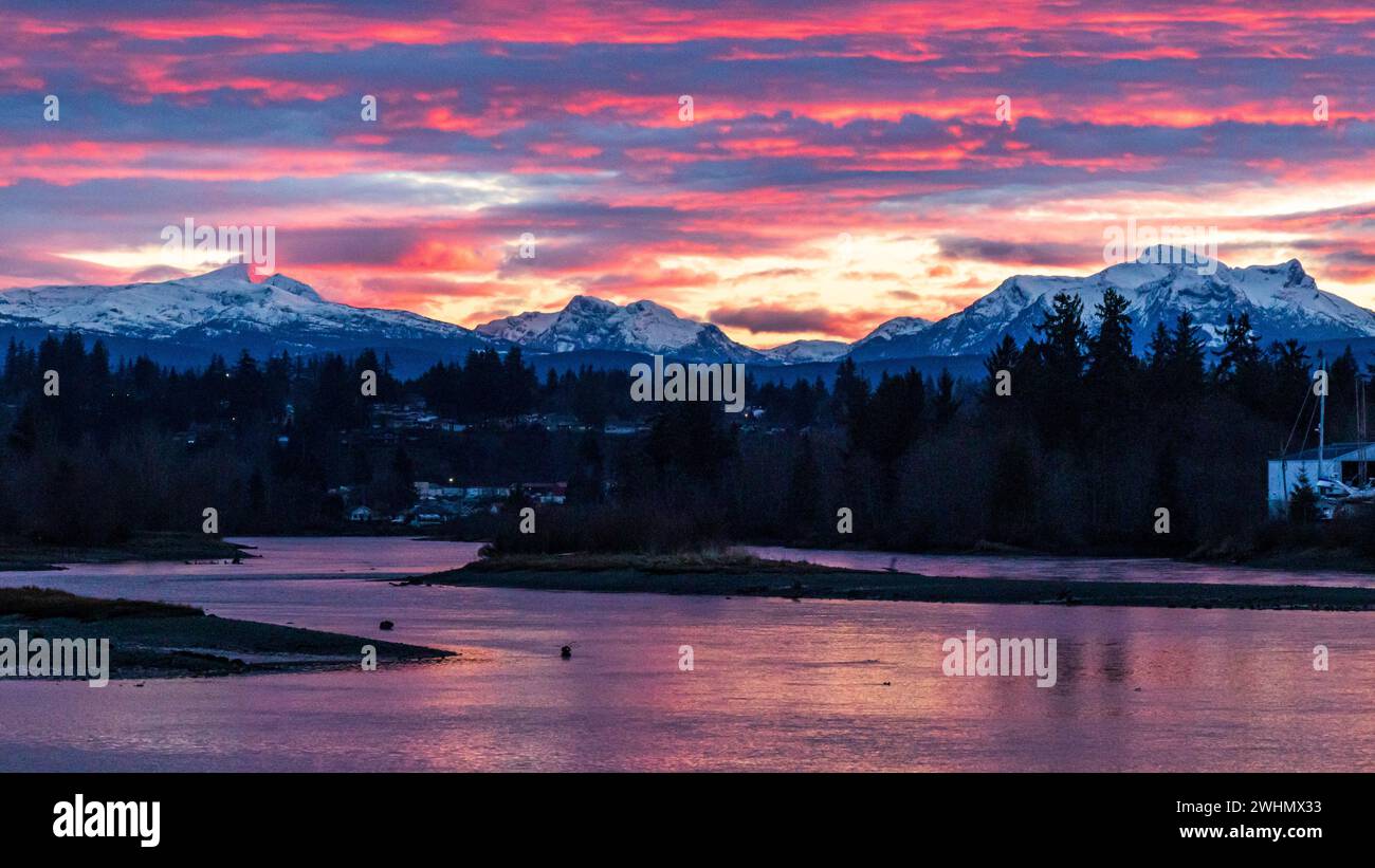 Roter Sonnenuntergang mit blauen und rey-Streifen, Winter in British Columbia, Rot, Rosa mit Silhouette der Berge. Sonnenuntergang an der Küste von British Columbia. Stockfoto