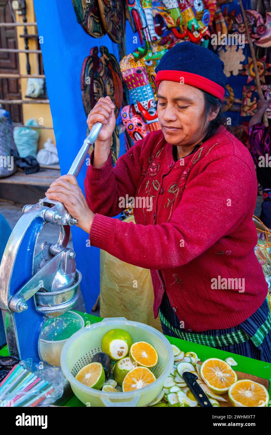 Chichicastenango, Guatemala.  Saft-Anbieter auf dem Markt, die Orangen auspressen. Stockfoto