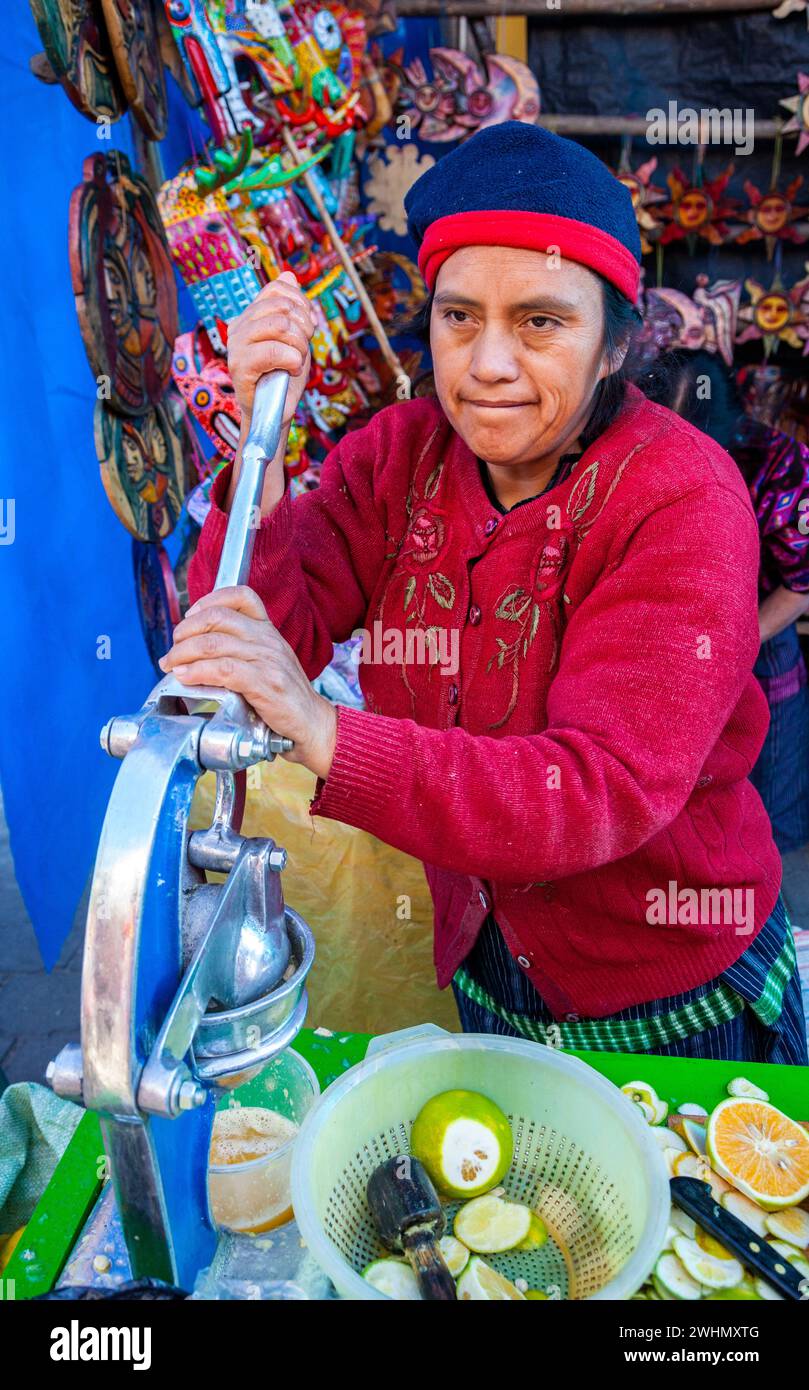 Chichicastenango, Guatemala.  Saft-Anbieter auf dem Markt, die Orangen auspressen. Stockfoto