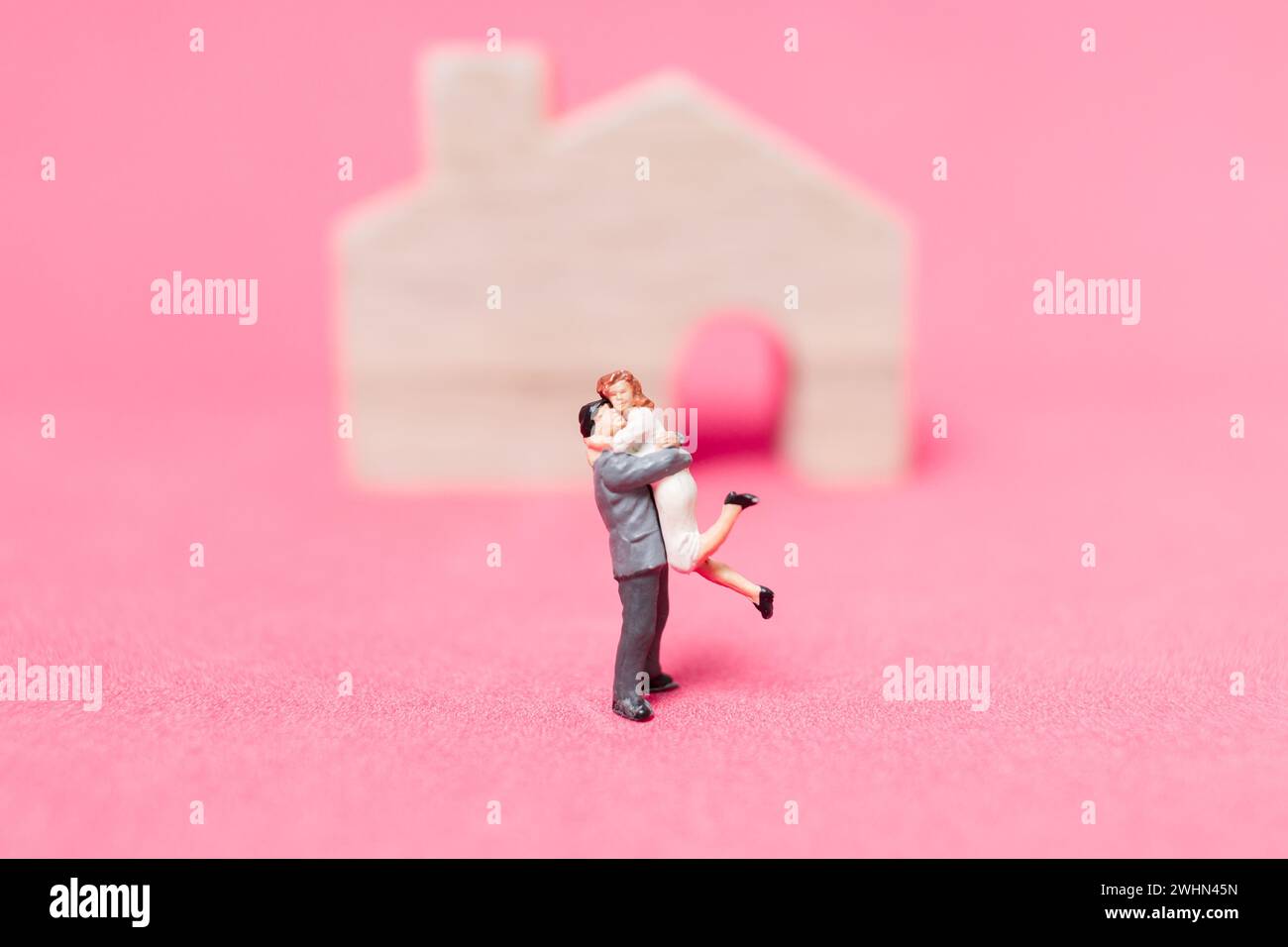 Paar mit Haus auf rosa Hintergrund, Stockfoto
