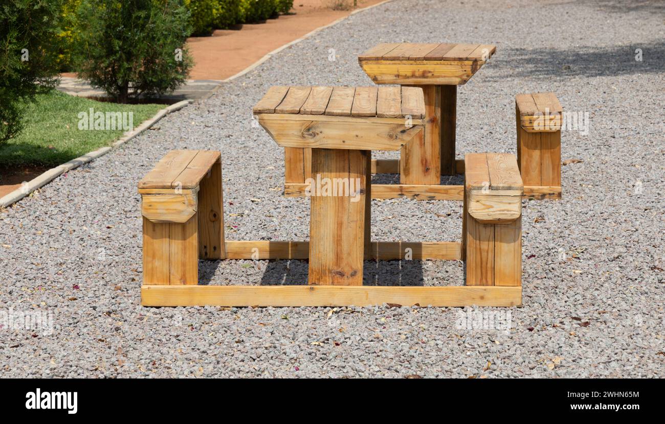 Holztisch und Stühle im Garten auf einer Kiesgasse Stockfoto