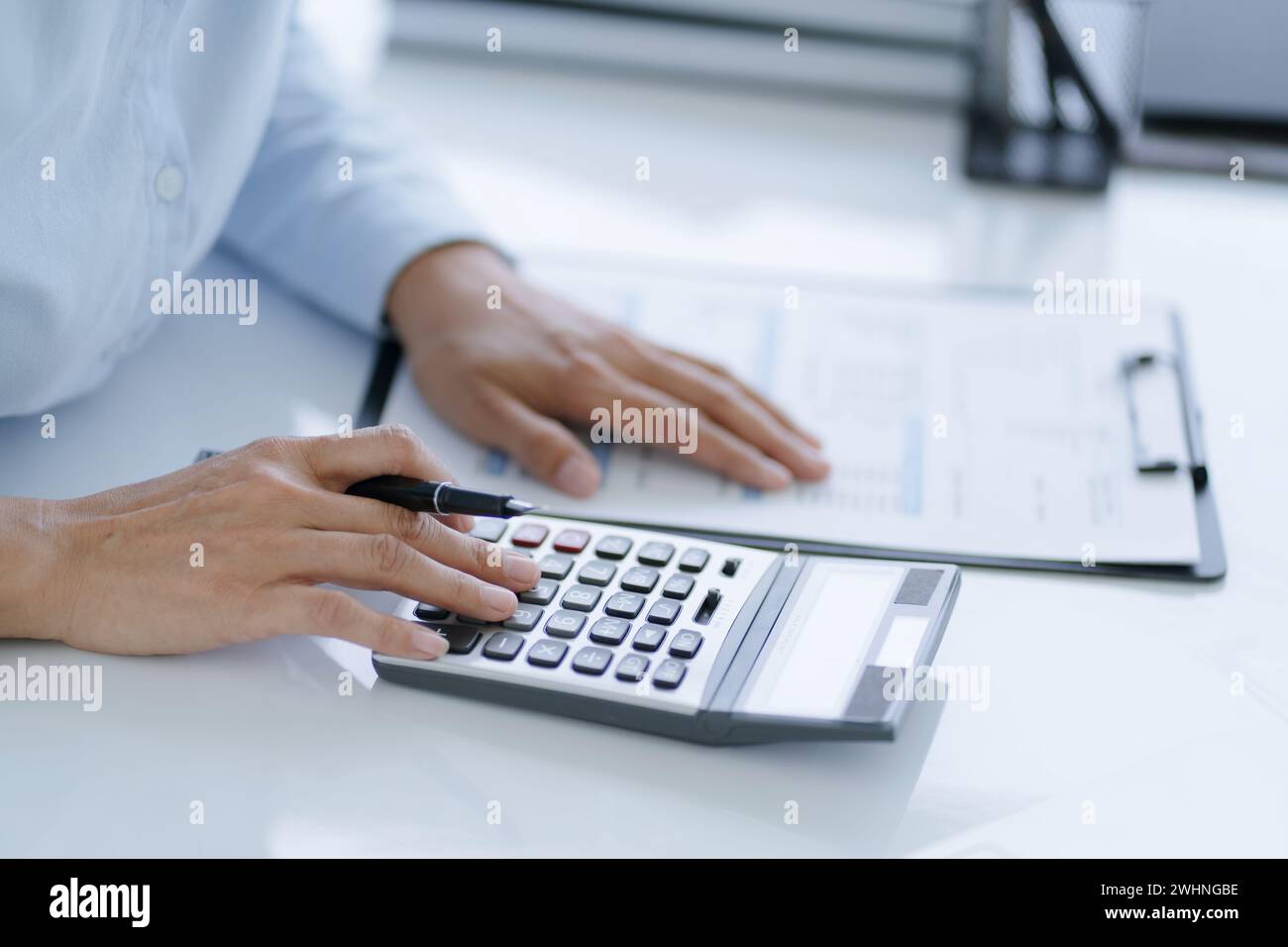 Geschäftsfrau Buchhalter Analyse von Investitionstabellen Rechnung und Drücken von Rechnerschaltflächen über Dokumenten. Buchhaltung Stockfoto