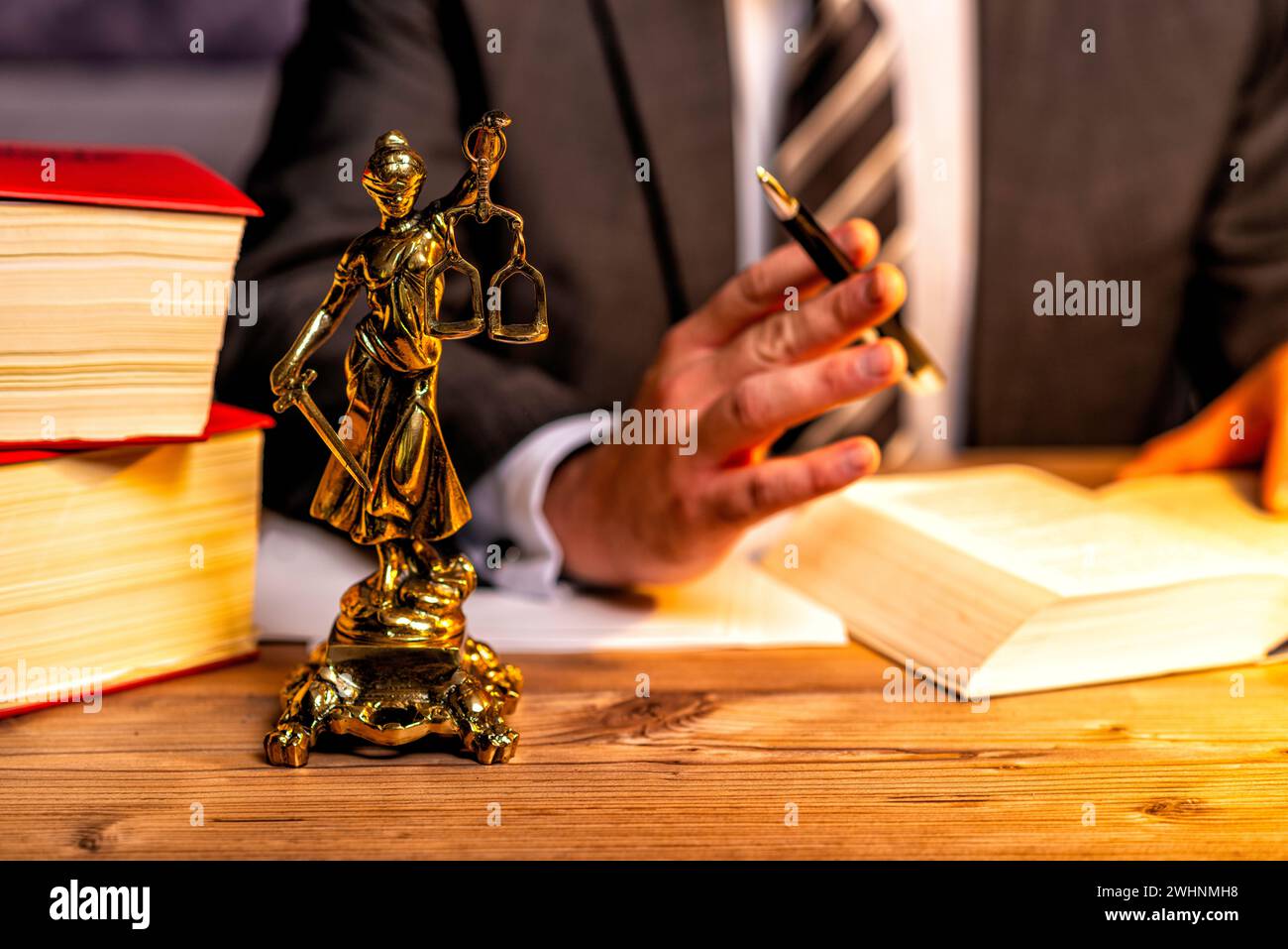 Büro eines Anwalts mit Statue von Lady Justice, Göttin Justitia, auf dem Schreibtisch Stockfoto