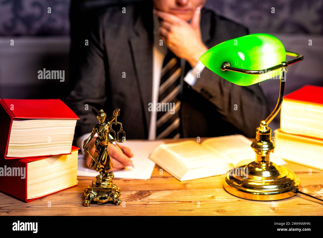 Büro eines Anwalts mit Statue von Lady Justice, Göttin Justitia, auf dem Schreibtisch Stockfoto