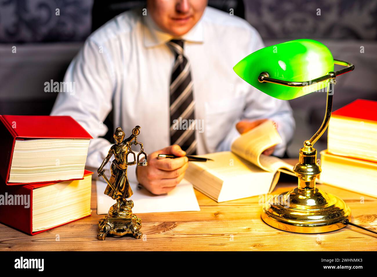 Büro eines Anwalts mit Statue von Lady Justice, Göttin Justitia, auf dem Schreibtisch Stockfoto