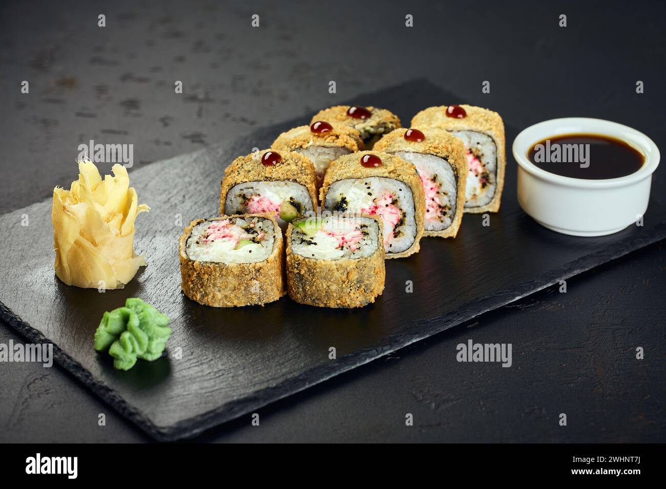 Tempura heiße Sushi-Rollen mit Krabben auf dunklem Hintergrund. Sushi-Menü. Japanisches Essen. Stockfoto