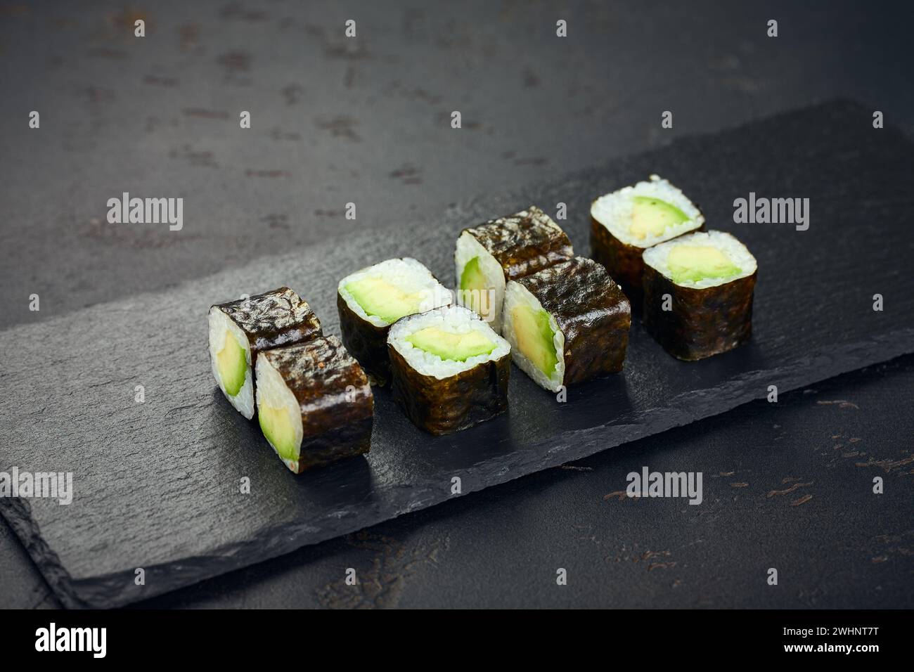 Rolle mit Avocado auf dunklem Hintergrund. Sushi-Menü. Japanisches Essen. Stockfoto