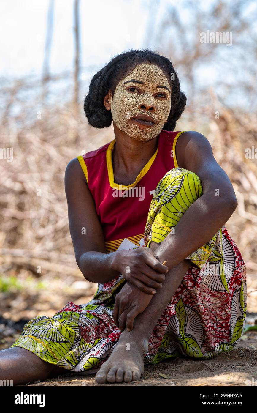 Eine madagassische Frau vor ihrer Hütte mit einem traditionell bemalten Gesicht. Madagassische Frauen malen ihre Gesichter, um ihre Gesichter zu schützen Stockfoto