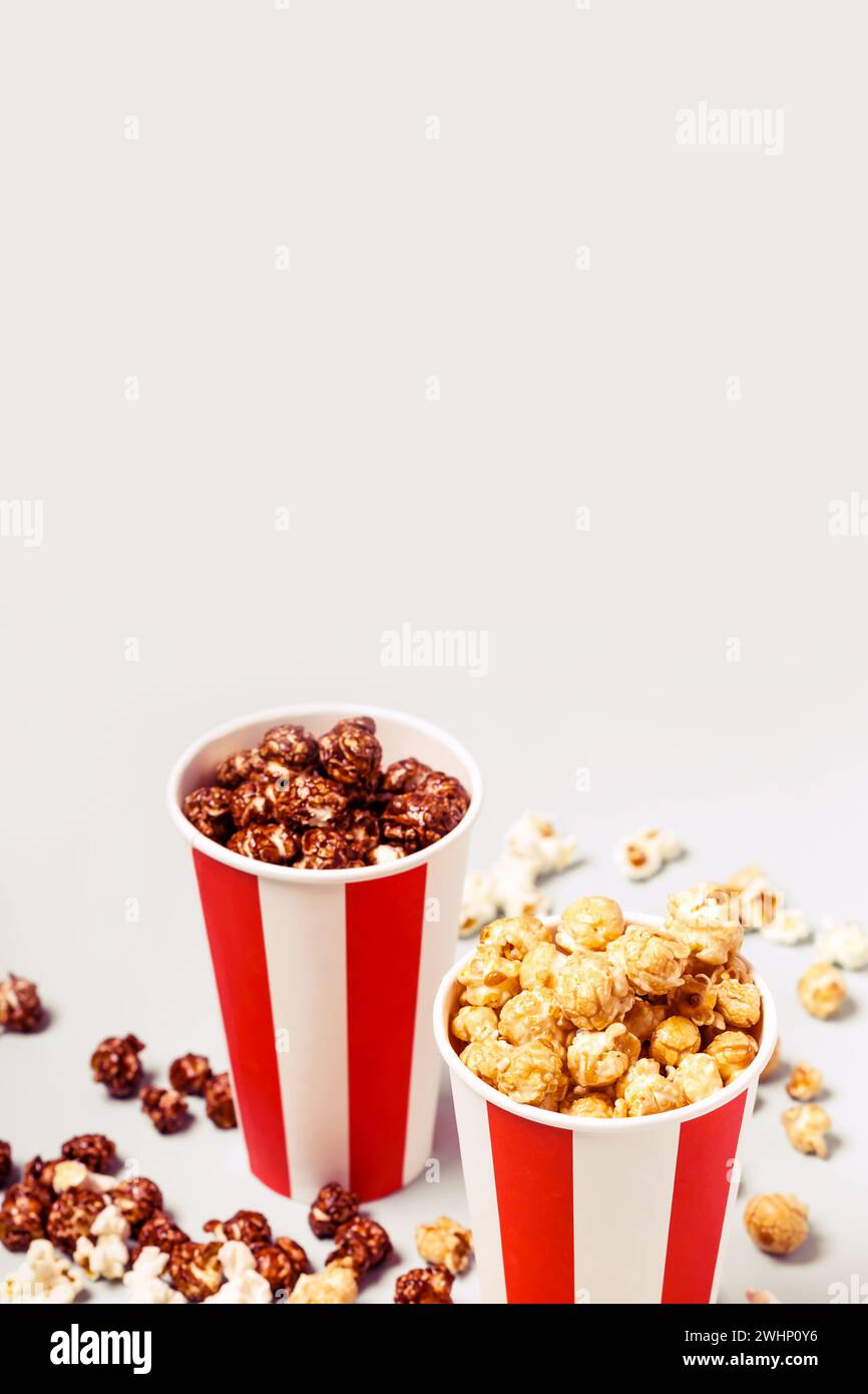 Popcorn-Set in weiß-roter Tasse mit Papierstreifen. Karamell und Schokoladenpopcorn Stockfoto