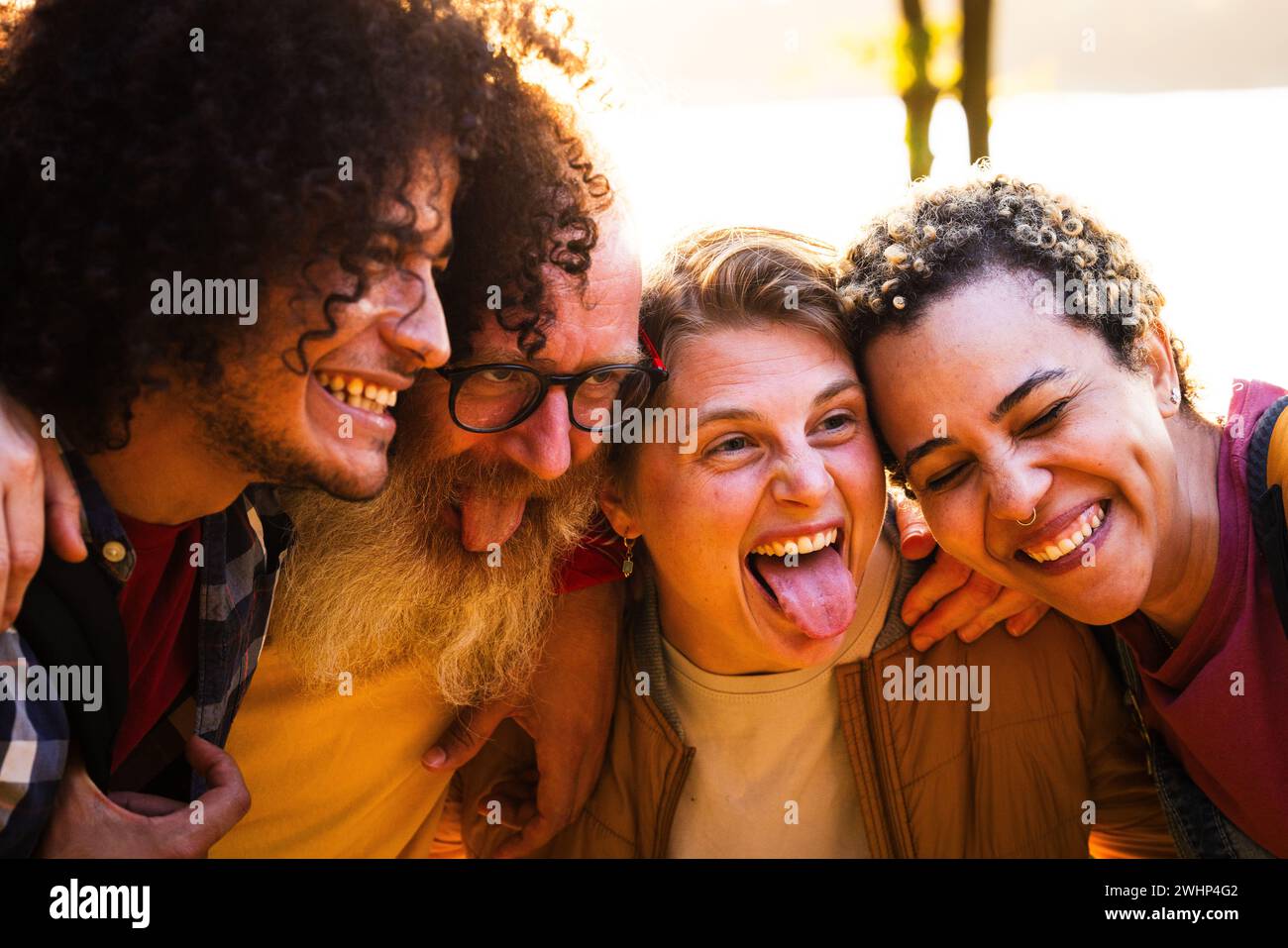 Fröhliche junge Gruppe von besten Freunden aus verschiedenen Rassen, die sich im Freien amüsieren. Millennial vielfältige Menschen, die die gemeinsame Zeit genießen, Tak Stockfoto