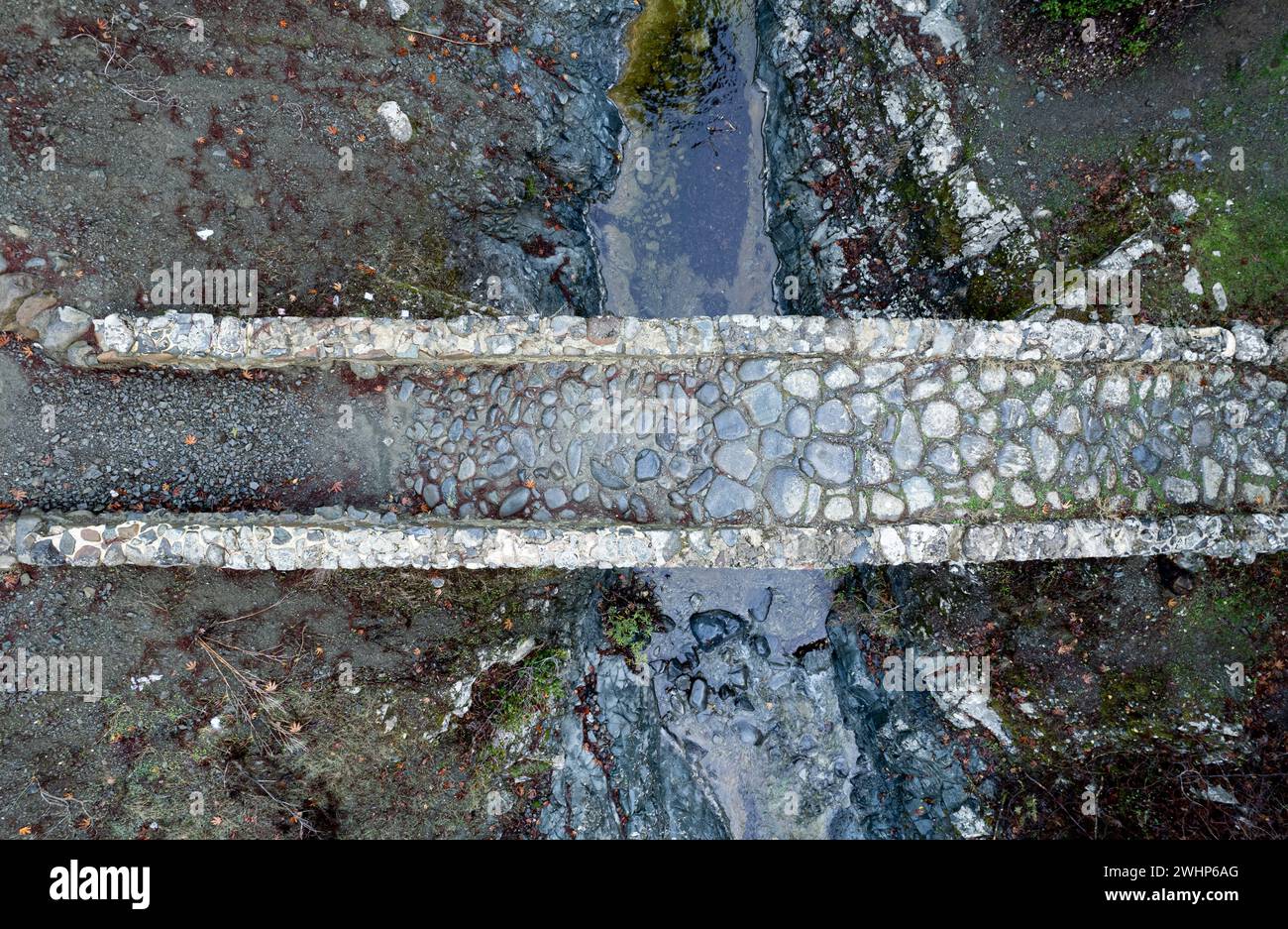 Luftaufnahme einer mittelalterlichen steinernen Brücke mit Wasser, das im Fluss fließt. Stockfoto