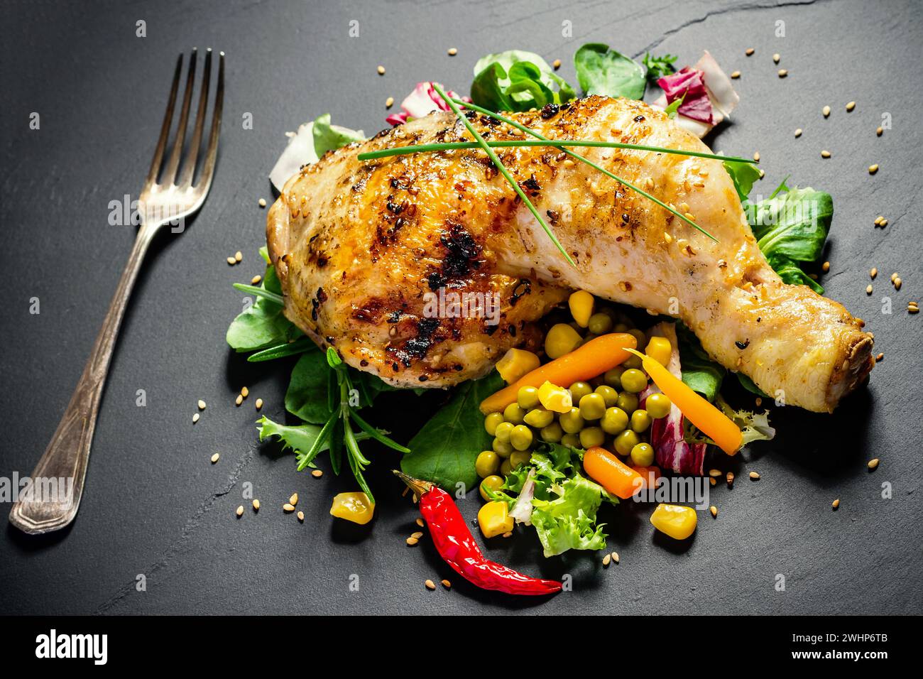 Gegrillte Hähnchenschenkel auf Schieferplatte Stockfoto