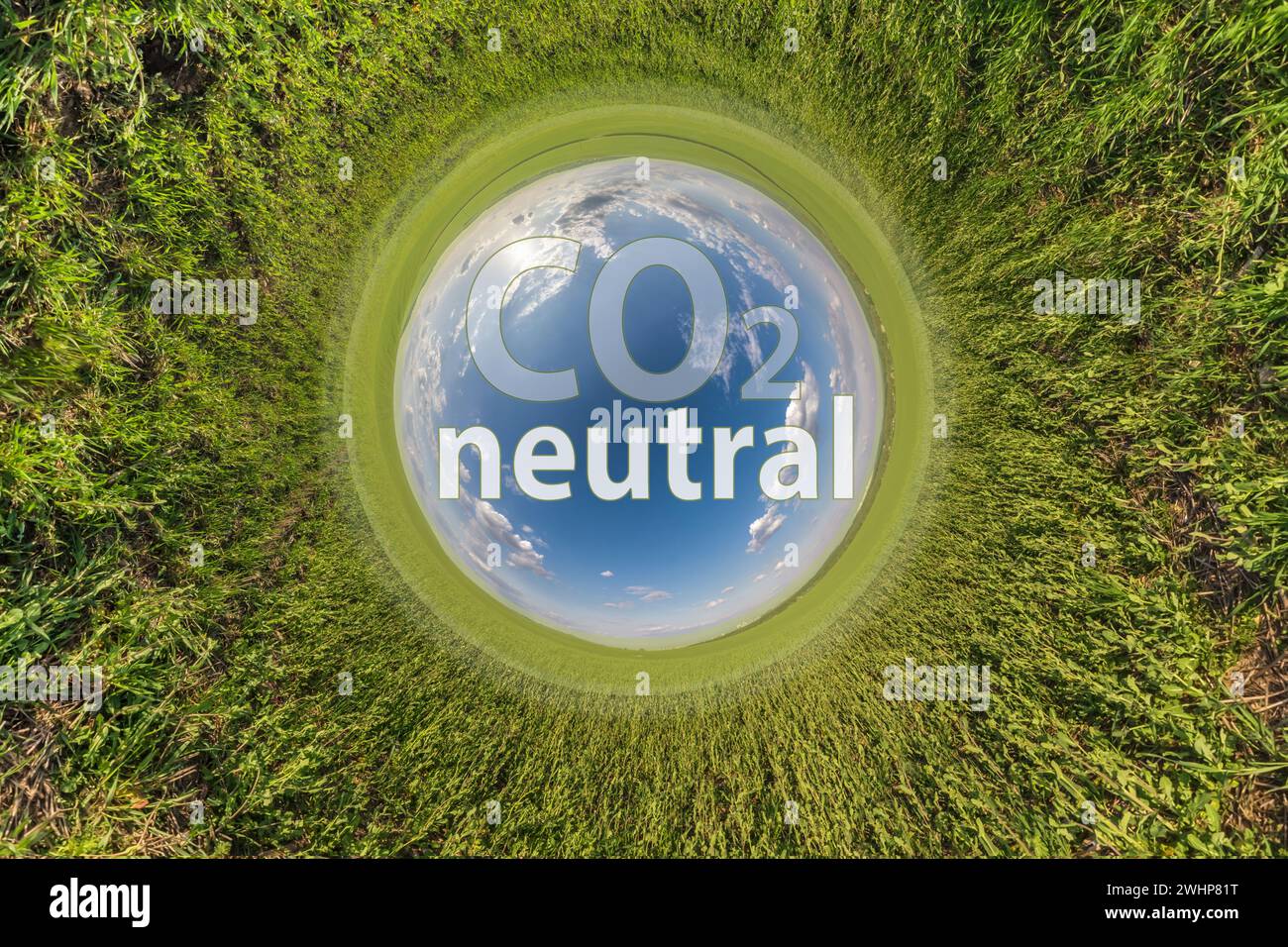 CO2 neutrales Textsymbol vor blauem kleinen Planeten auf grünem Grashintergrund Stockfoto