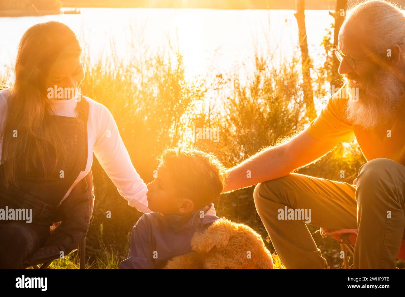 Familiencamping am Forest Lake bei Sonnenuntergang Stockfoto