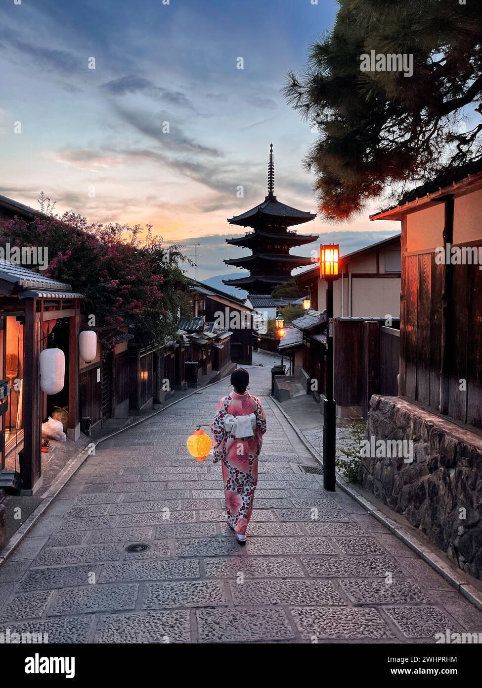 Asiatische Reisende, die traditionelle japanische Kimonos tragen und eine Laterne halten, spazieren durch den Bezirk Higashiyama bei Sonnenuntergang am 29. August 2022 in Kyoto, Japan. Higashiyama-ku bewahrt das Aussehen und die Atmosphäre des Feudalzeitalters Japans in einem holzgebauten historischen Viertel mit engen Gassen, gesäumt von traditionellen Töpfereien, Teehäusern und Restaurants. Foto von Victor Fraile / Power Sport Images Stockfoto