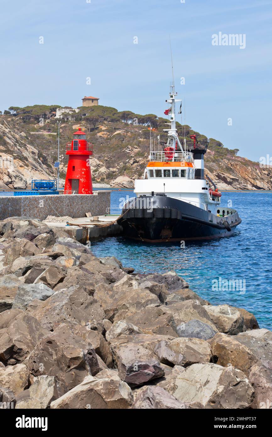 Fischtrawler und kleiner roter Leuchtturm Stockfoto