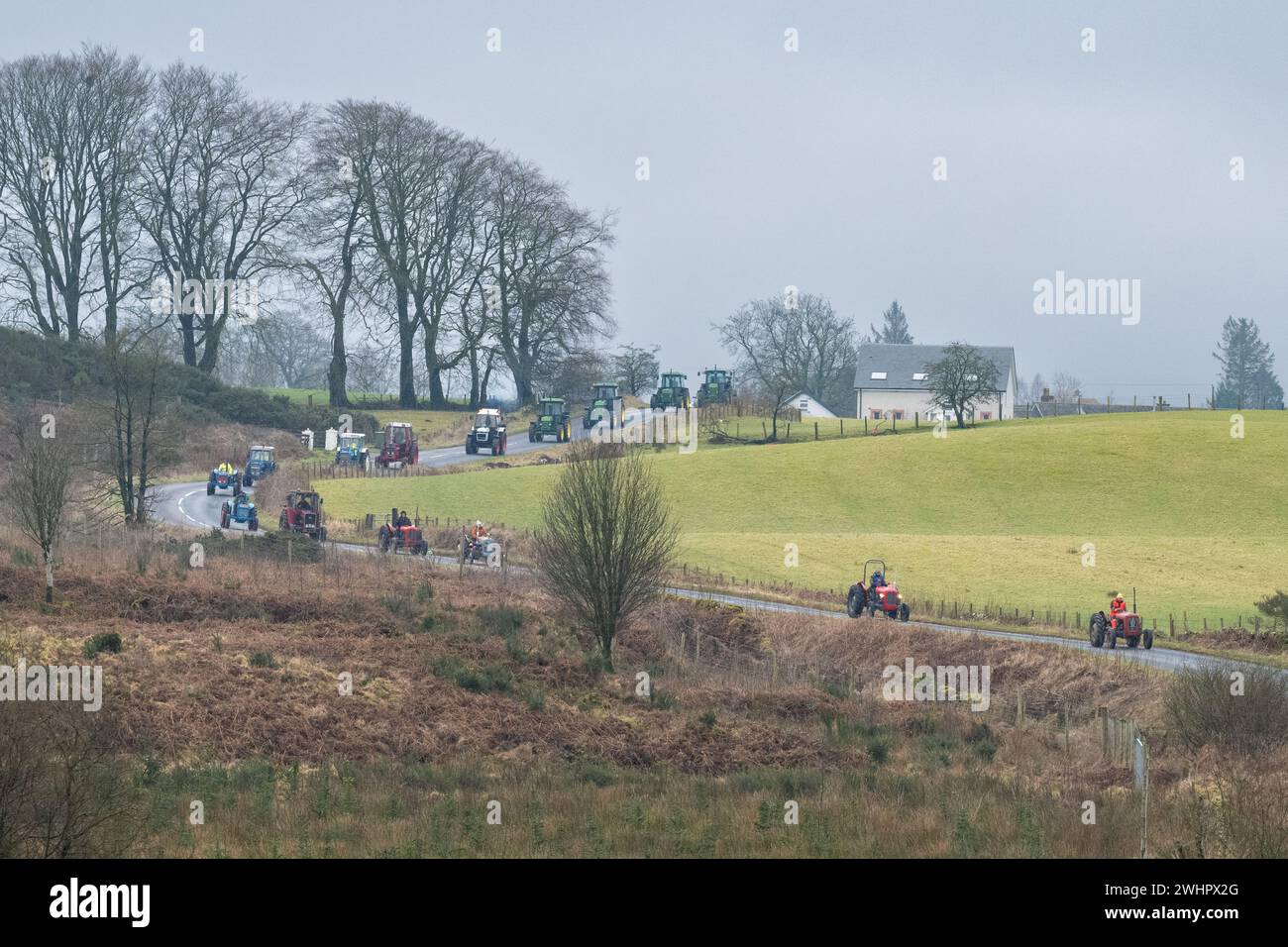 Balfron, Stirling, Schottland, Großbritannien. Februar 2024. Die Trossachs Tractor Run Spendenaktion für Chest Heart and Stroke Scotland. Die Wohltätigkeitsveranstaltung wurde von Robert Wilson aus Kippen in Erinnerung an den berühmten Arnprior-Schmied Bobby Gunn organisiert, der 2017 plötzlich bei seiner Arbeit starb. Über 40 Traktoren fahren auf der 50 km langen Strecke durch Stirling. Spenden an die Wohltätigkeitsorganisation können über Roberts "nur geben"-Seite gemacht werden. Quelle: Kay Roxby/Alamy Live News Stockfoto