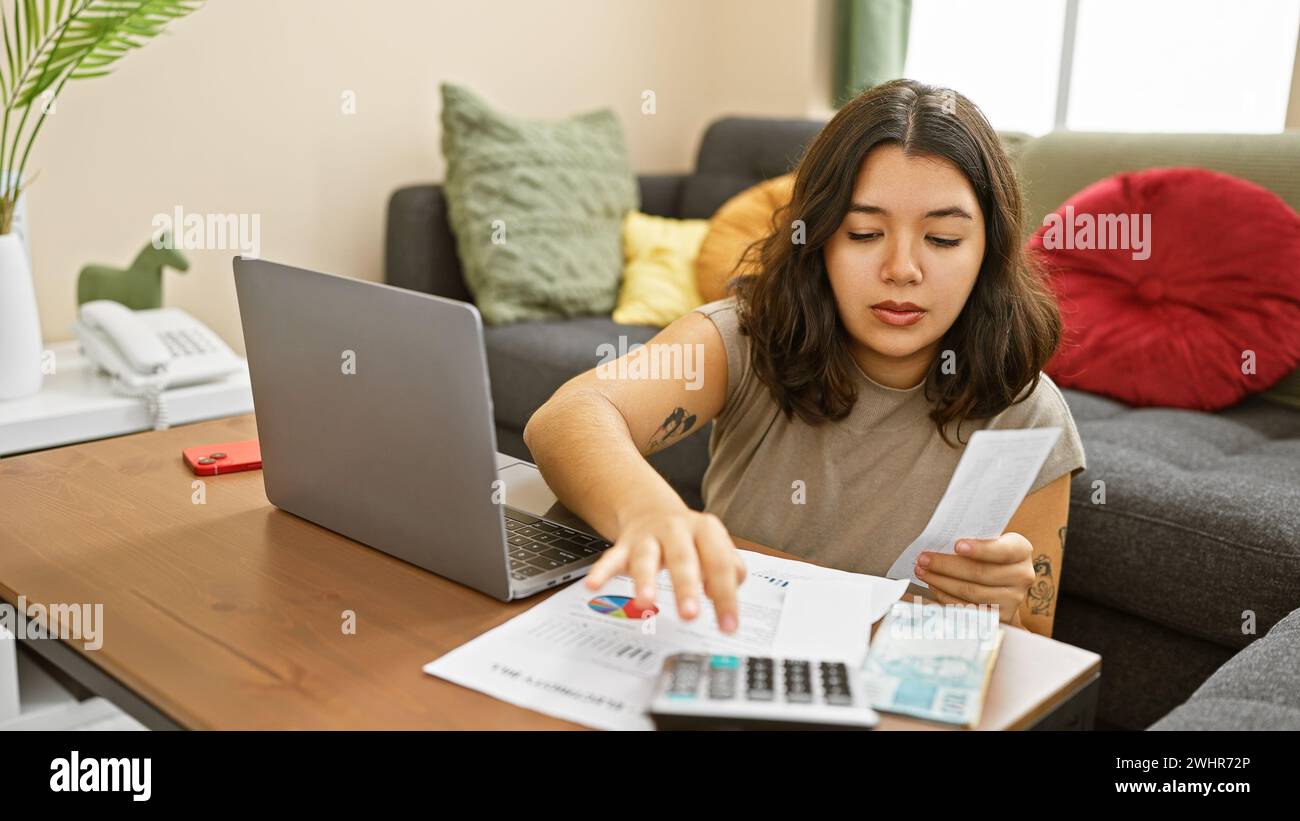 Hispanische Frau überprüft Finanzen mit Rechner, Rechnungen und Laptop im Innenraum. Stockfoto