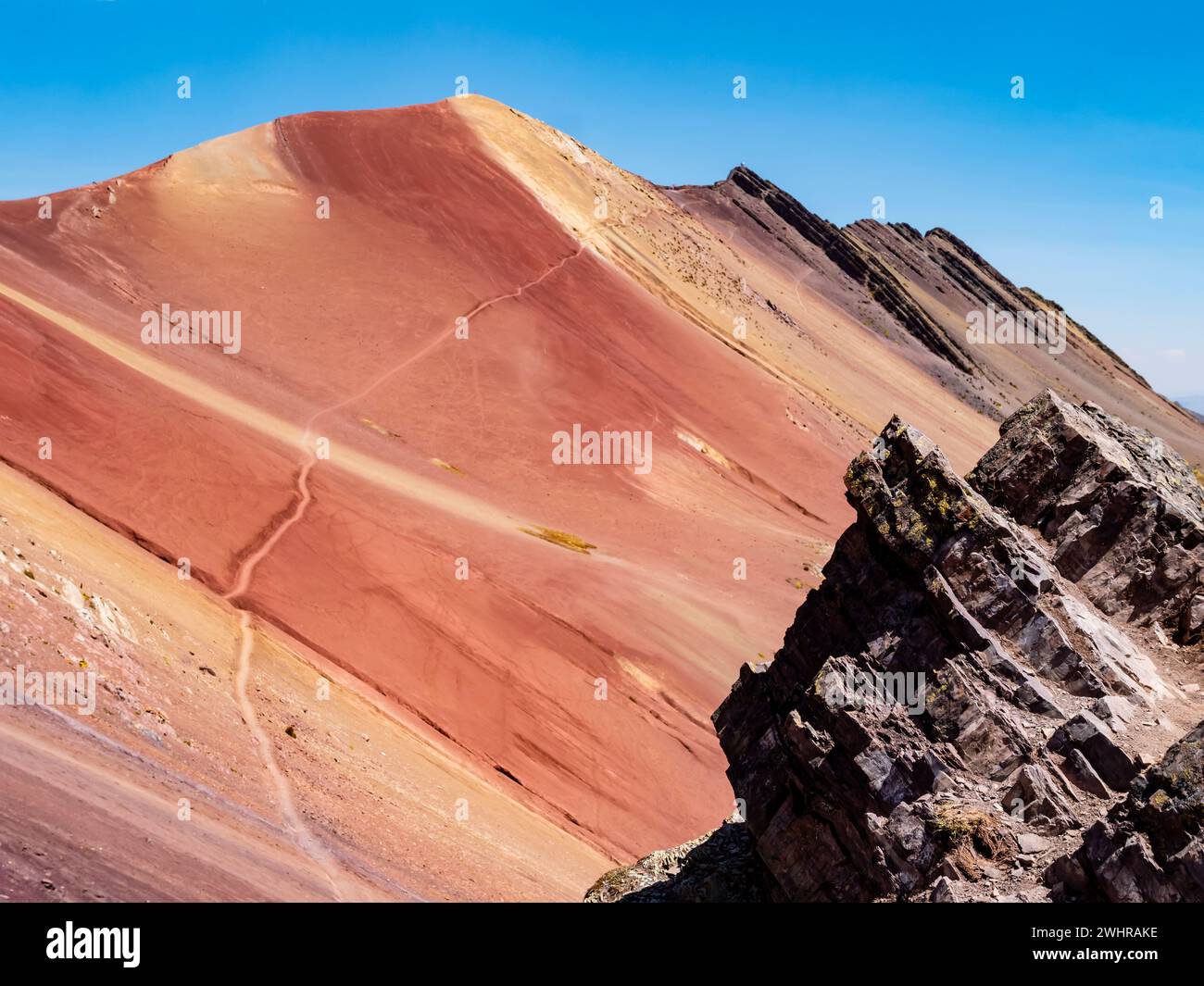 Farbige Felsen des Roten Tals (valle rojo) mit abenteuerlichem Pfad, der zum Gipfel des Berges führt, Region Cusco, Peru Stockfoto