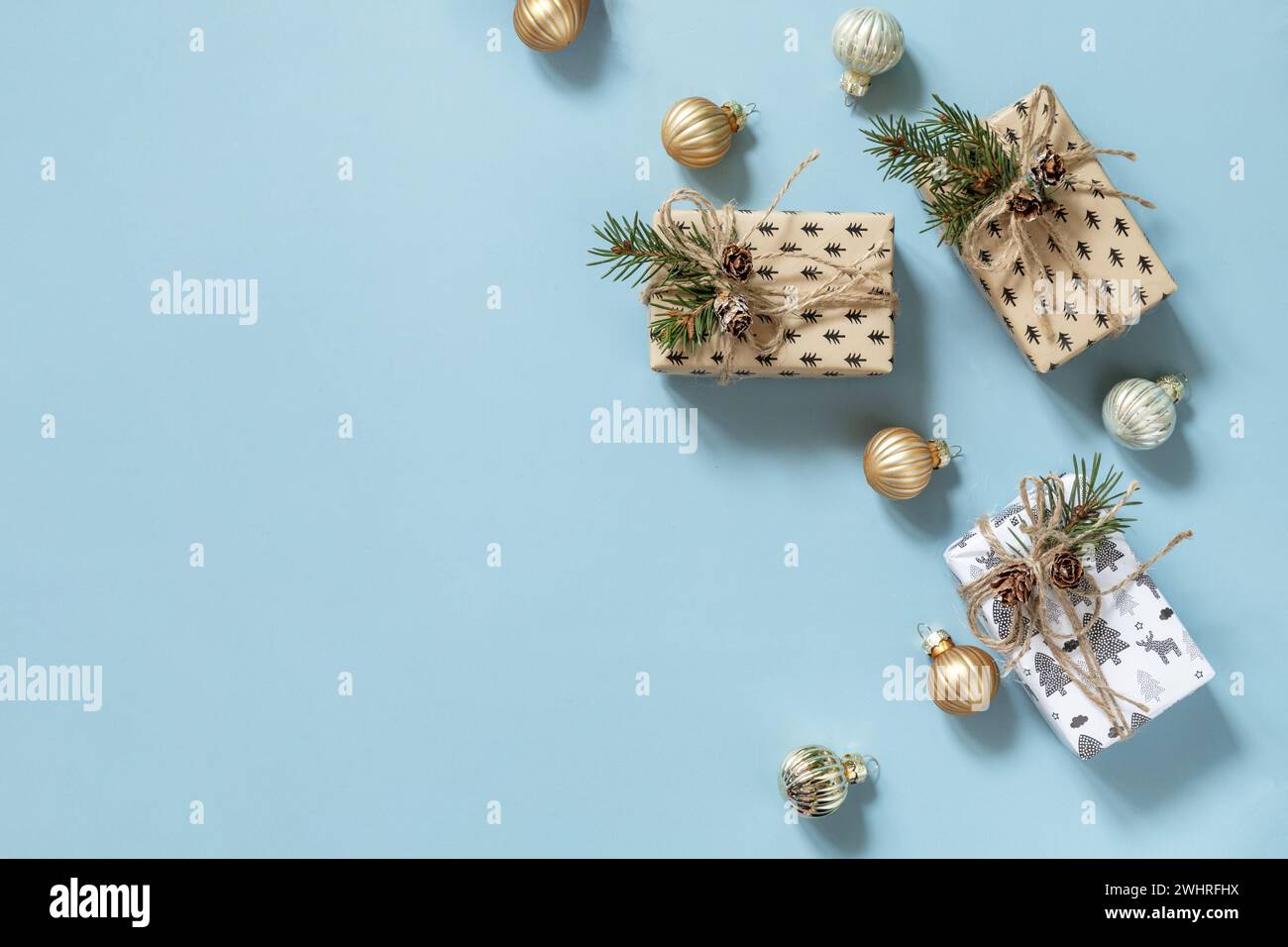 Weihnachtsmockup mit Weihnachtsgeschenken auf blauem Hintergrund. Vorbereitung auf Feierlichkeiten Weihnachten. Draufsicht flacher Hintergrund. C Stockfoto