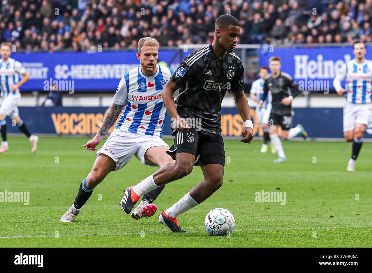HEERENVEEN, NIEDERLANDE - 11. FEBRUAR: Luuk Brouwer vom SC Heerenveen, Jorrel Hato von Ajax kämpfen um den Ball während des niederländischen Eredivisie-Spiels zwischen SC Heerenveen und AFC Ajax im Abe Lenstra Stadion am 11. Februar 2024 in Heerenveen, Niederlande. (Foto: Pieter van der Woude/Orange Pictures) Stockfoto