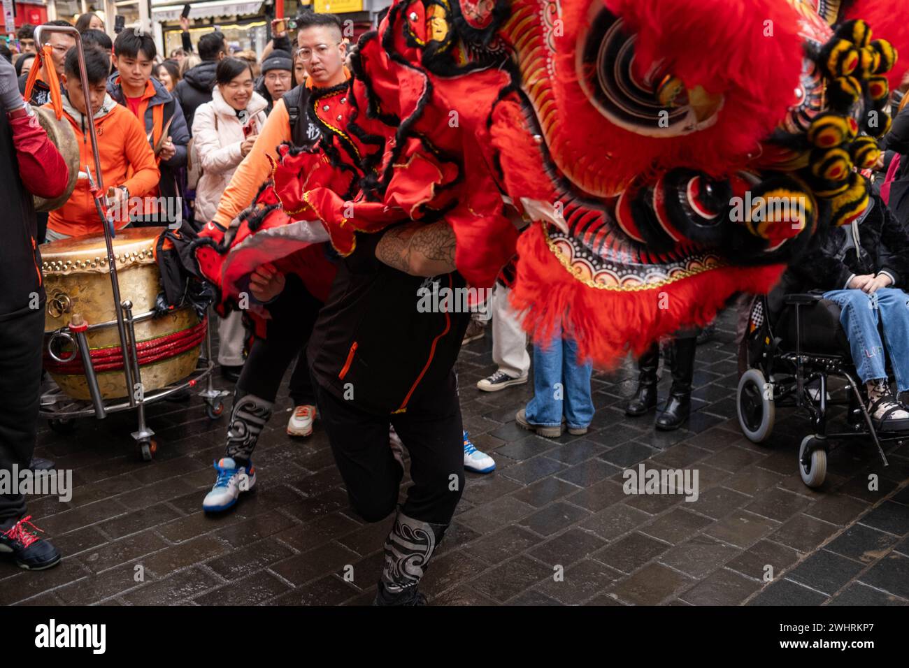 Menschenmassen versammeln sich um einen Drachentänzer in China Town, London. Tausende feiern das chinesische Neujahr, das Jahr des Drachen. Stockfoto