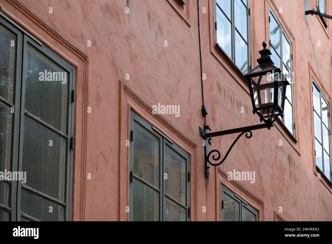 Antike Laterne im Freien, montiert auf brauner Wand des Gebäudehintergrunds. Alte Vintage-Lampe aus Metall und Glas. Unter Ansicht. Stockfoto