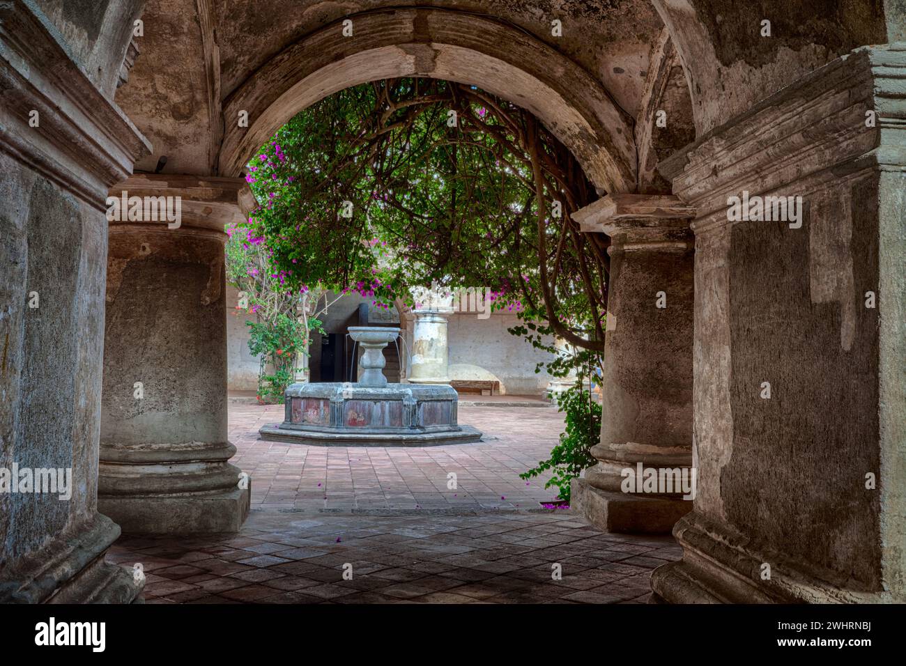 Antigua, Guatemala. Kapuzinerkloster, Erbaut 1736. Korridor im Erdgeschoss und Innenhof mit Brunnen. Stockfoto