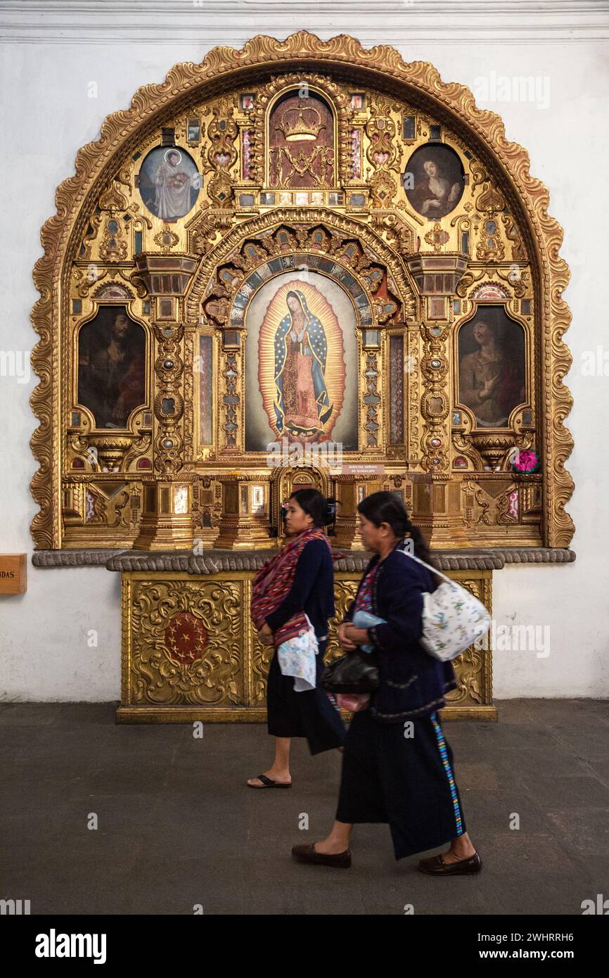 Antigua, Guatemala. Maya-Frauen gehen am Heiligtum vorbei zu unserer Lieben Frau von Guadalupe, Kirche von San Francisco. Stockfoto