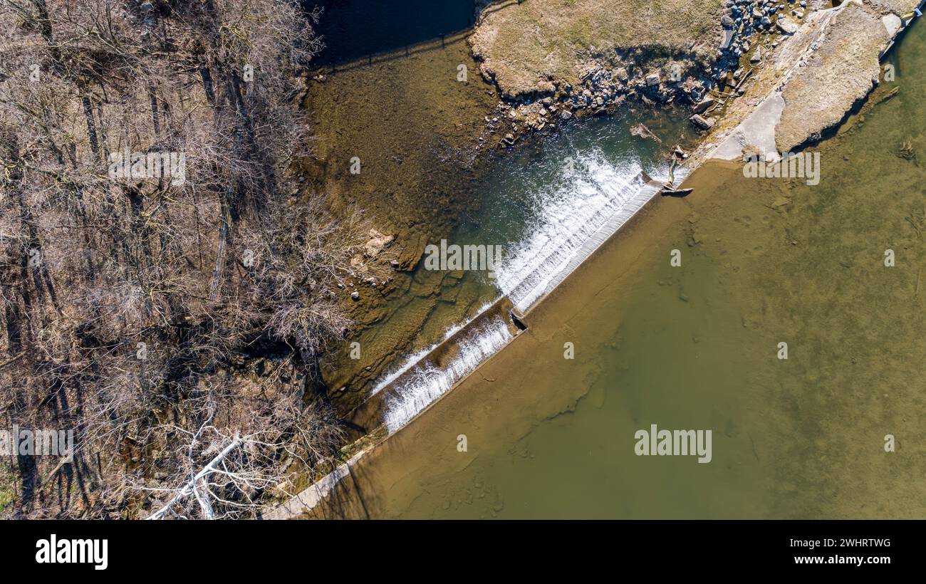 Luftaufnahme nach unten auf einen von Menschen geschaffenen Wasserfall für eine Mühle, an einem sonnigen Tag Stockfoto