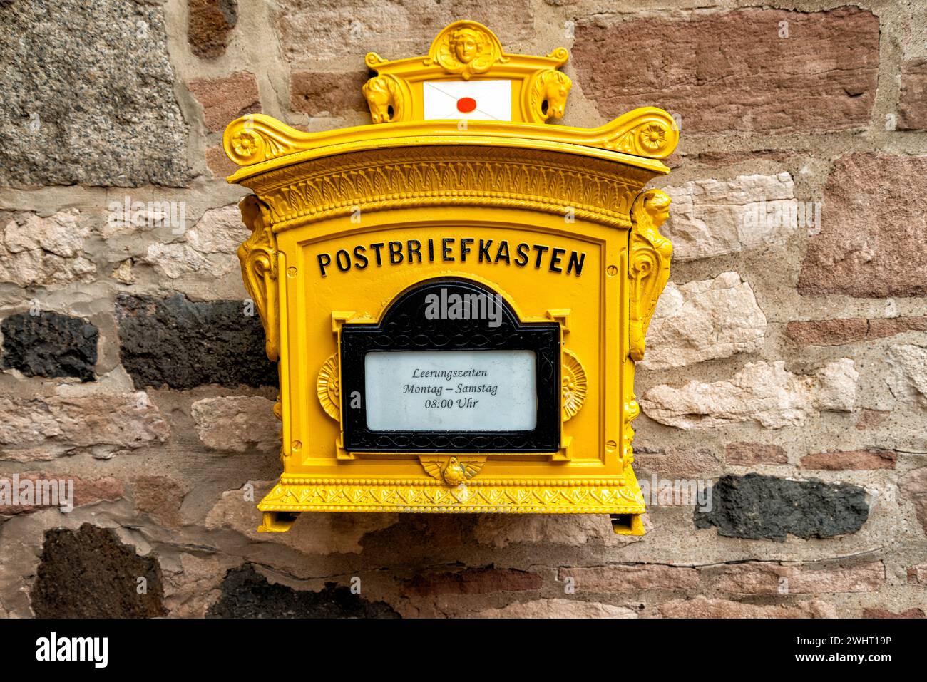 Historischer gelber Briefkasten in Deutschland Stockfoto