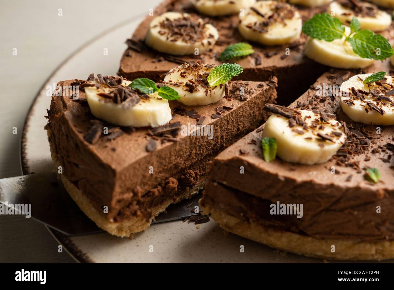 Köstlicher und flauschiger Schokoladen-Mousse-Kuchen mit Bananen- und Orangenaroma. Stockfoto