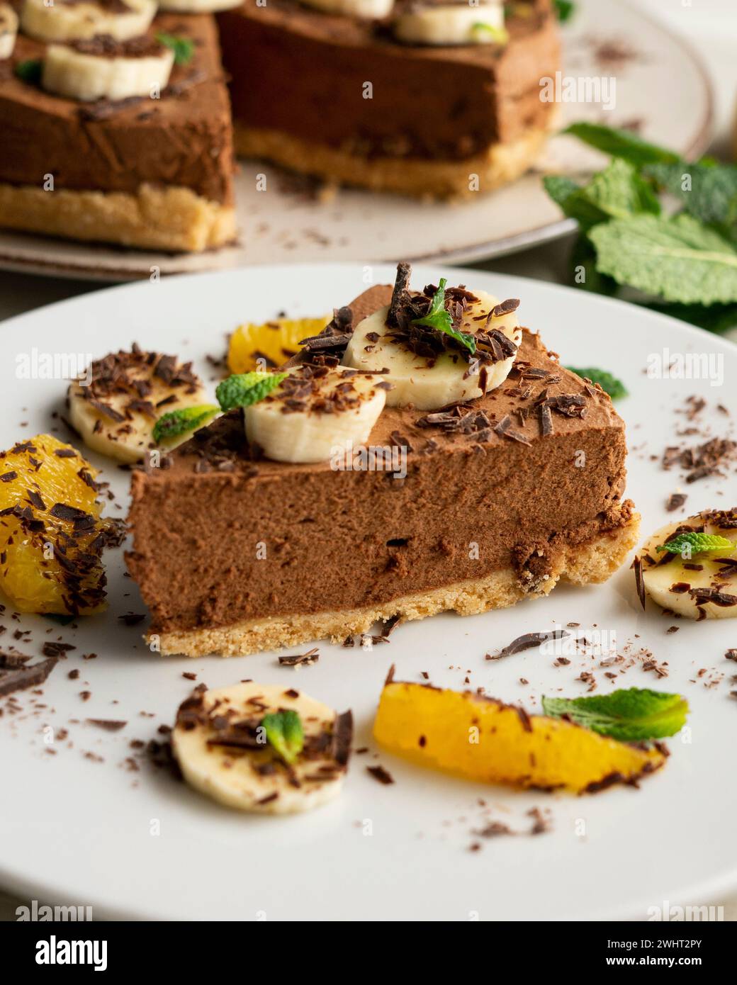 Köstlicher und flauschiger Schokoladen-Mousse-Kuchen mit Bananen- und Orangenaroma. Stockfoto