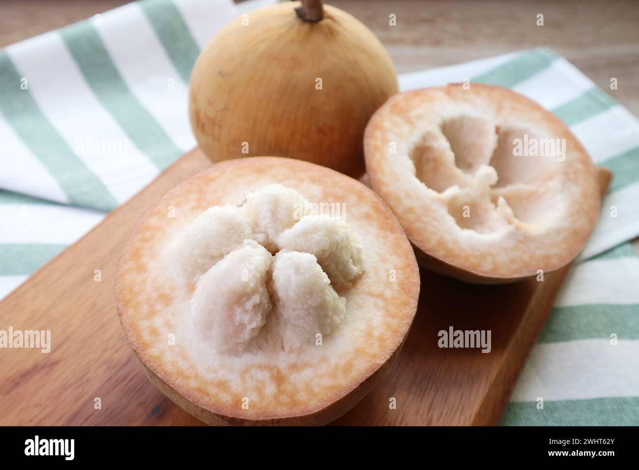 Nahaufnahme der geöffneten frischen Reifen Baumwollfrucht oder Santol-Frucht mit ganzen Früchten im Hintergrund Stockfoto