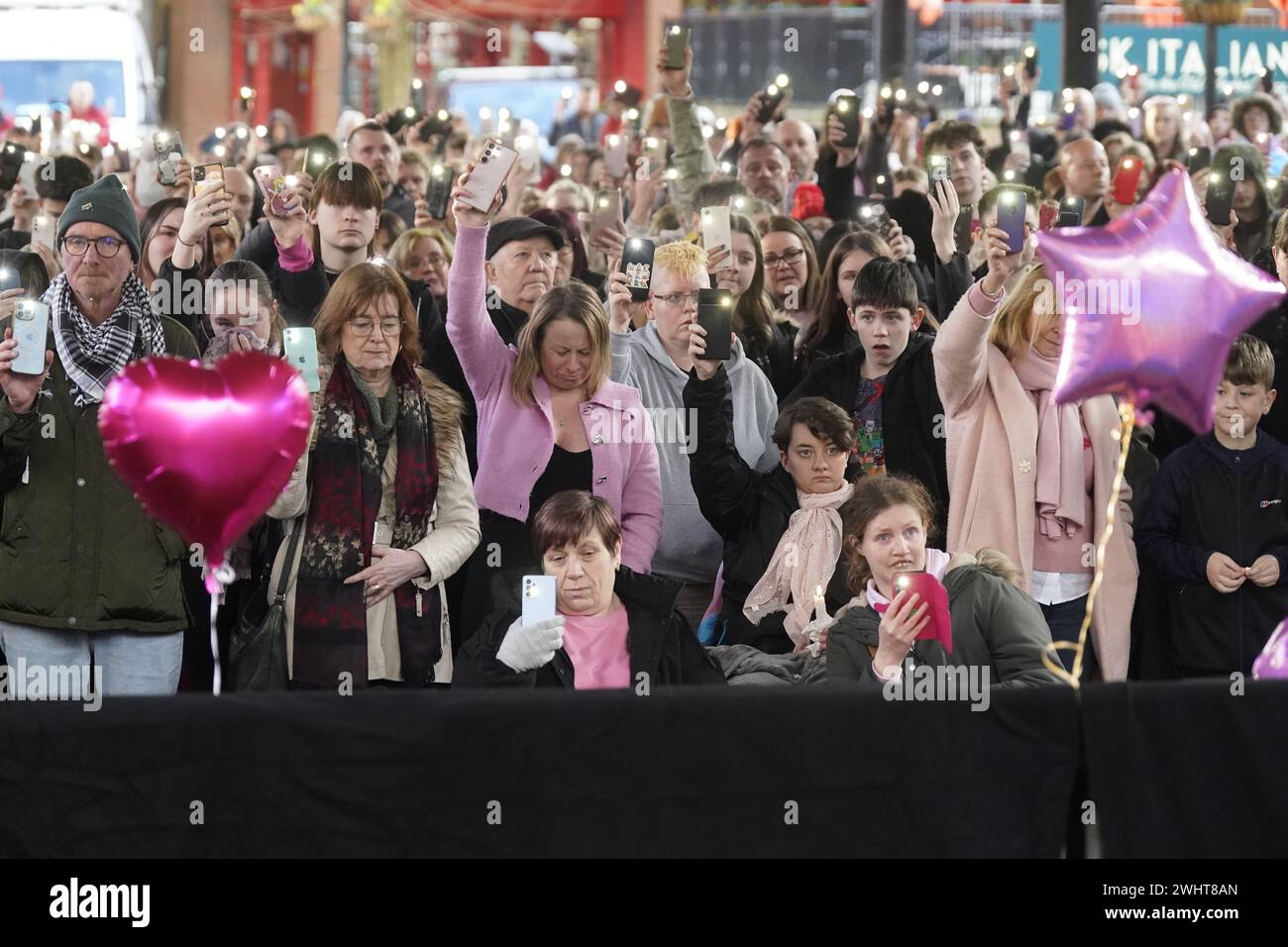 Die Leute halten ihre Telefone hoch, während einer zweiminütigen Mahnwache am Golden Square, Warrington, anlässlich des ersten Jahrestages des Mordes an der 16-jährigen Brianna Ghey. Bilddatum: Sonntag, 11. Februar 2024. Stockfoto