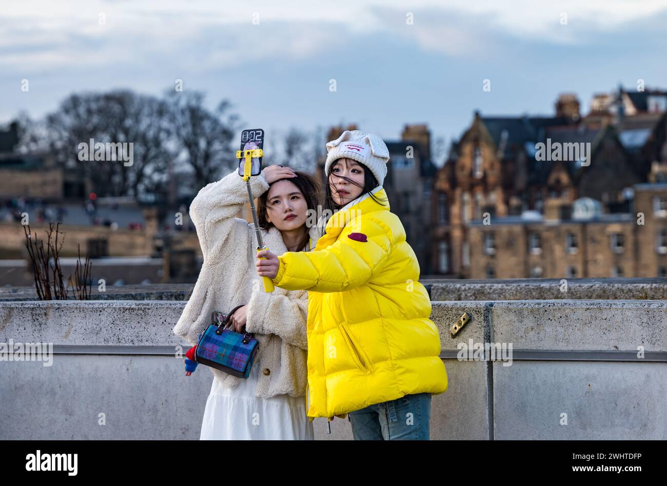 Asiatische Mädchen, die ein Foto mit einem Selfie-Stick von der Skyline von Edinburgh machen, Schottland, Großbritannien Stockfoto