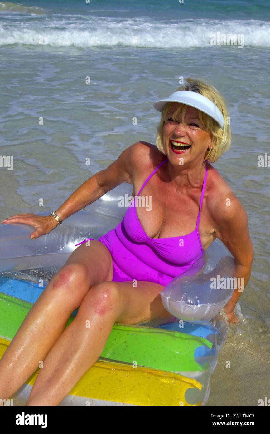 Seniorin, Frau mit Luftmatratze am Strand auf Ibiza Stockfoto