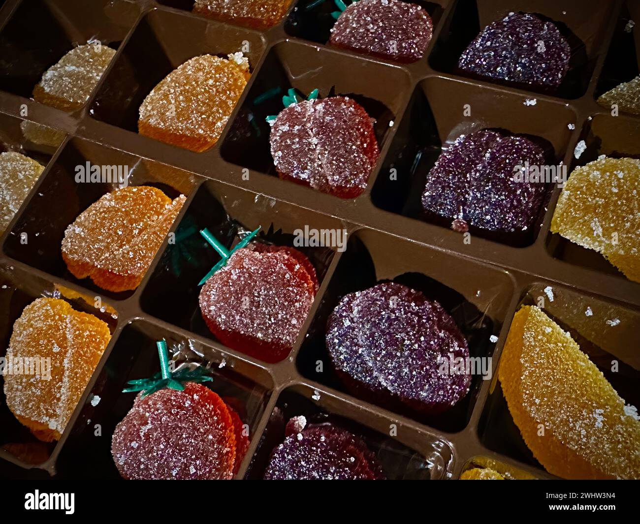 Gezuckerte Fruchtgelees, elegant angeordnet: Eine Auswahl an glitzernden Zitrusfrüchten und Beeren Stockfoto