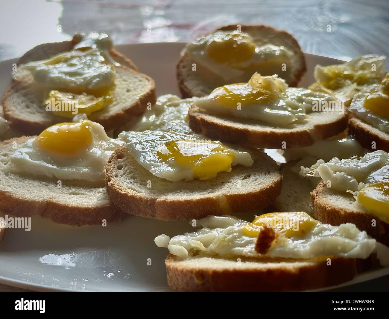 Hausgemachte Mini-Sunny-Side-up-Eier auf Toast: Eine herrliche Frühstückspräsentation Stockfoto