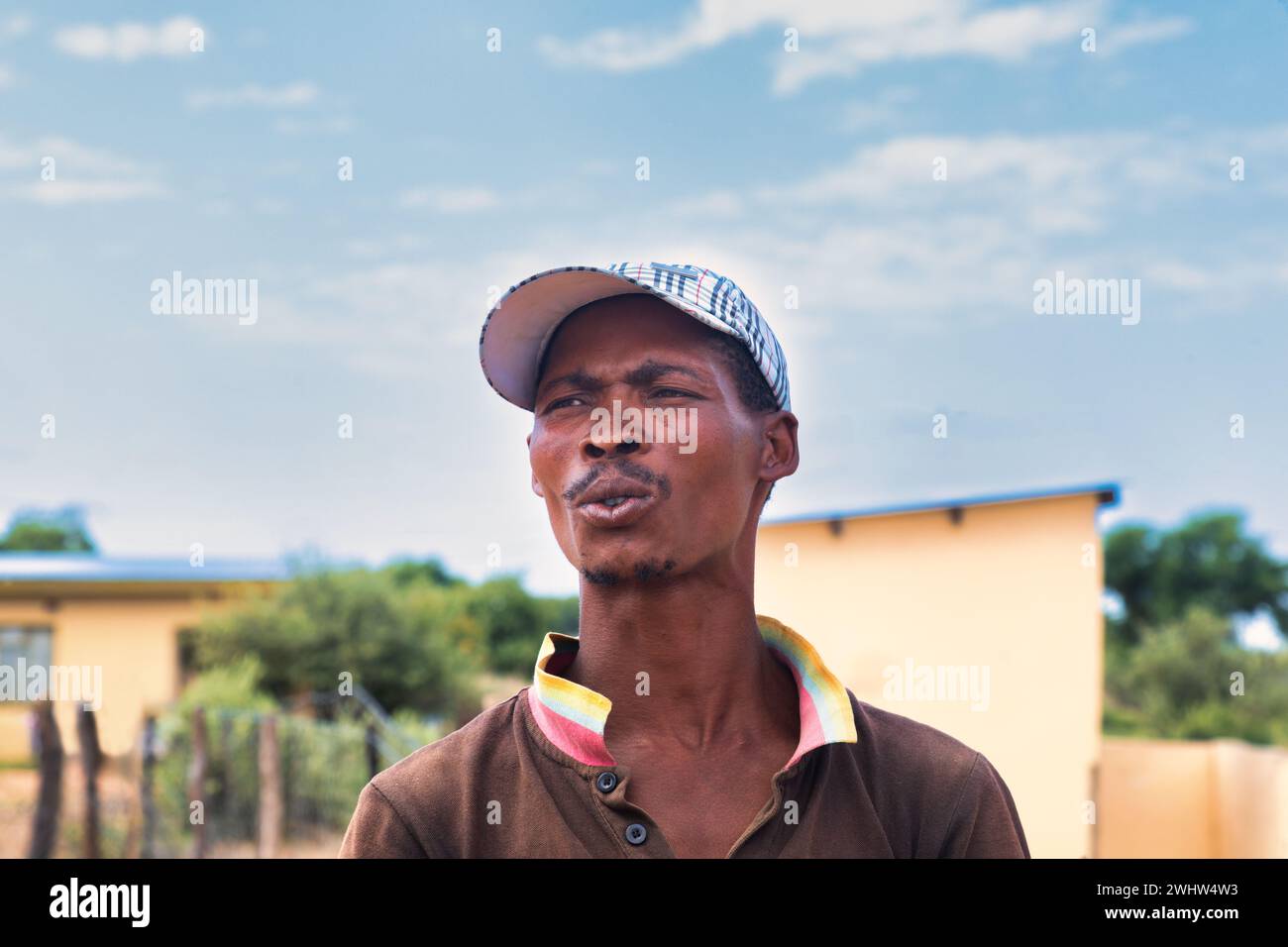 Dorf, Porträt afrikanischer Männer mit Mütze, tagsüber vor dem Haus Stockfoto