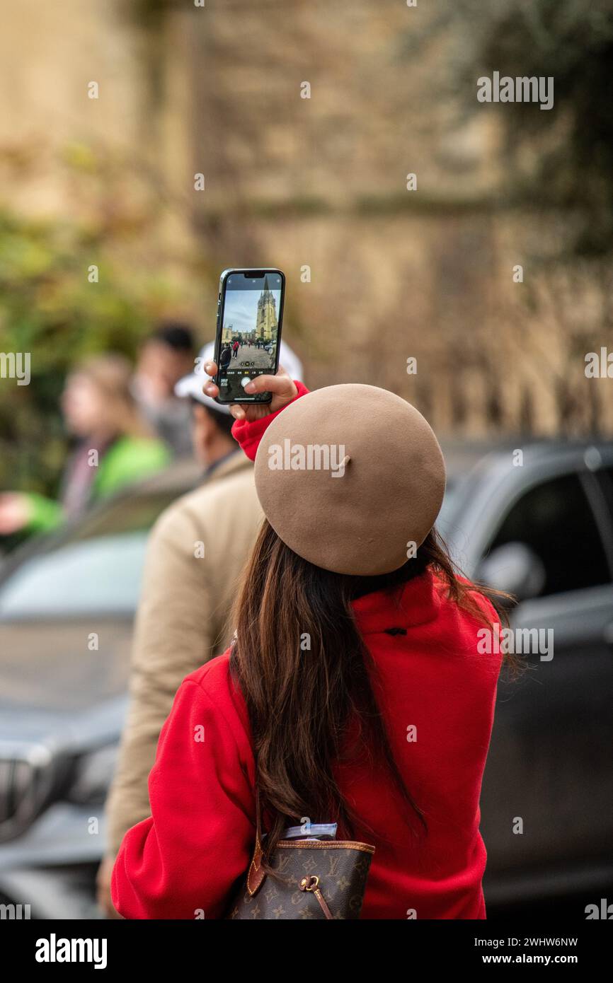 Tourist in einer roten Jacke, der ein Foto auf einem Handy macht Stockfoto