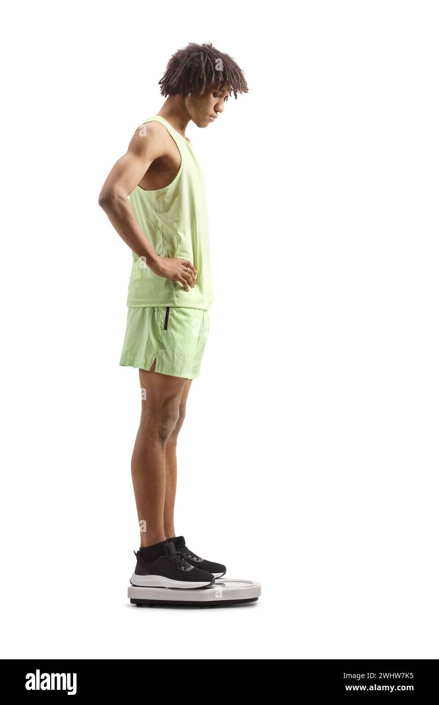 afroamerikaner in Sportbekleidung überprüft Gewicht auf einer Waage isoliert auf weißem Hintergrund Stockfoto